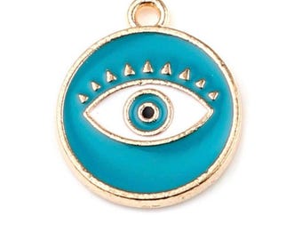 Puede incluir: Un dije redondo dorado con fondo de esmalte turquesa. El dije presenta un ojo blanco con pupila negra, rodeado por un borde turquesa y pequeños triángulos dorados. Un pequeño lazo en la parte superior para sujetar.