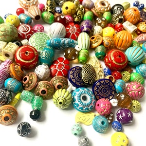 May include: A large assortment of colorful, patterned, and textured beads. The beads are made of various materials, including wood, glass, and plastic. They are perfect for jewelry making, crafting, and home decor.