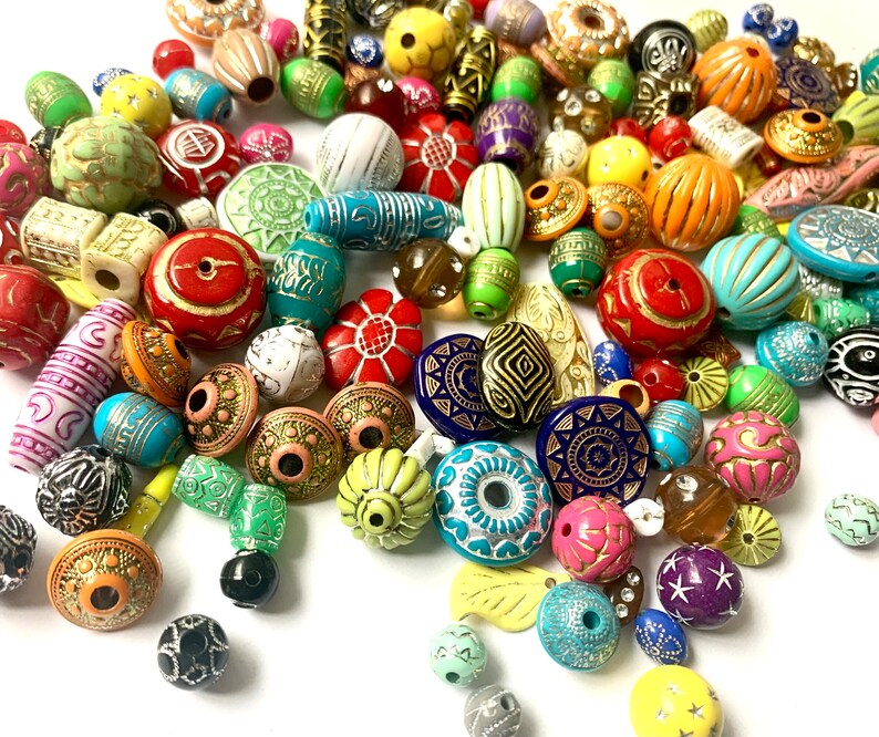 May include: A large assortment of colorful, patterned, and textured beads. The beads are made of various materials, including wood, glass, and plastic. They are perfect for jewelry making, crafting, and home decor.
