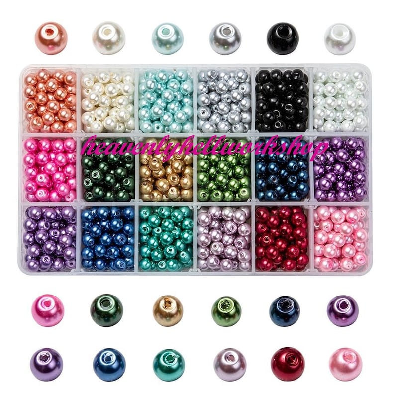 May include: A clear plastic organizer filled with various colors of round beads. The beads are in shades of pink, green, gold, blue, black, and white. The top row has individual beads in the same colors. The text "heavenlyhollyshop" is visible.