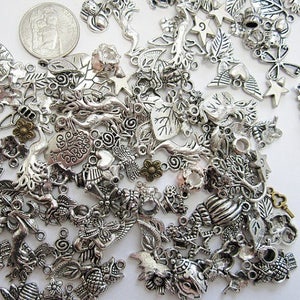 Puede incluir: Un gran surtido de abalorios de metal plateado con varios dise&ntilde;os inspirados en la naturaleza, incluyendo hojas, &aacute;rboles, corazones, estrellas y llaves. Los abalorios son perfectos para la elaboraci&oacute;n de joyas, el scrapbooking y otros proyectos de manualidades.