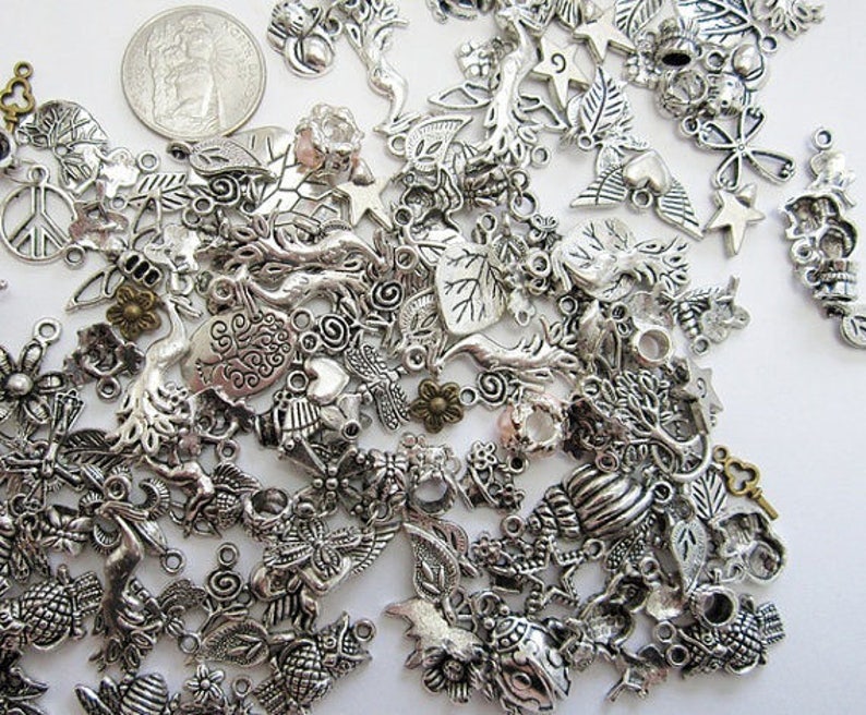 Puede incluir: Un gran surtido de abalorios de metal plateado con varios dise&ntilde;os inspirados en la naturaleza, incluyendo hojas, &aacute;rboles, corazones, estrellas y llaves. Los abalorios son perfectos para la elaboraci&oacute;n de joyas, el scrapbooking y otros proyectos de manualidades.