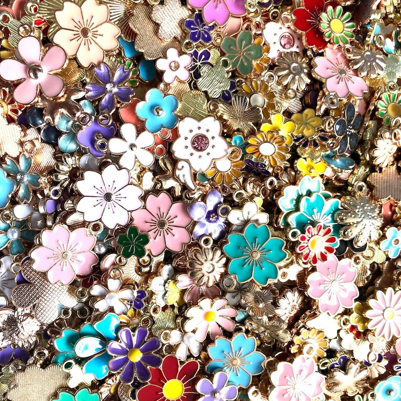 Puede incluir: Un gran surtido de abalorios de flores de esmalte de colores con detalles dorados. Los abalorios son perfectos para la elaboraci&oacute;n de joyas, el scrapbooking y otros proyectos de manualidades.