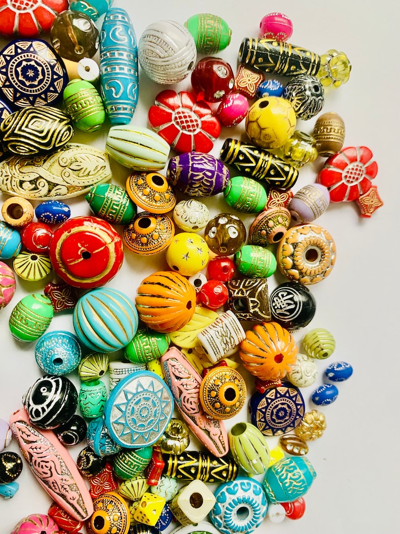 May include: A large collection of colorful wooden beads with various patterns and designs. The beads are made of wood and have a variety of shapes, including round, oval, and square. The beads are perfect for making jewelry, crafts, and other projects.