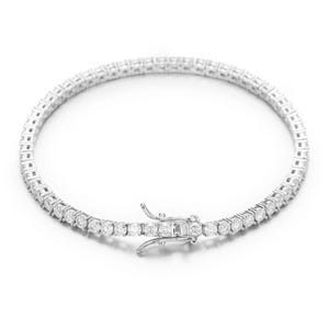 May include: A silver tennis bracelet with a row of round, clear gemstones. The bracelet has a secure clasp and is displayed on a white background. The gemstones are evenly spaced and reflect light.