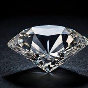 May include: A clear, colorless, round brilliant-cut diamond featuring numerous triangular and kite-shaped facets that reflect light to create sharp, geometric patterns. The gemstone has a pointed culet at the base and a wide, flat table top.