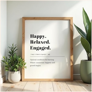 Può includere: Una stampa incorniciata con le parole "Happy. Relaxed. Engaged." in nero. La stampa include una definizione e la frase "Optimal conditions for learning. Where connection happens and growth begins." La cornice è marrone chiaro.