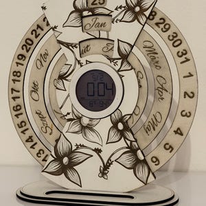 May include: A white ceramic mug with a black handle and the text "But First, Coffee" in a bold, black font. The mug is set against a blurred background, suggesting a cozy setting.