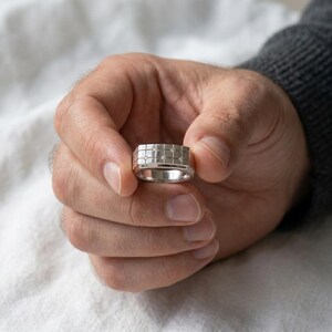Modern geometric mens diamond ring with grid pattern design in white gold finish on soft white fabric background
Gold, Sterling Silver, Lab Diamond, Moissanite, Cubic Zirconia
925 Sterling Silver
10K Gold
14K Gold
18K Gold
Platinum
White Gold
Yellow Gold
Rose Gold
Lab Grown Diamond
Moissanite
Cubic Zirconia