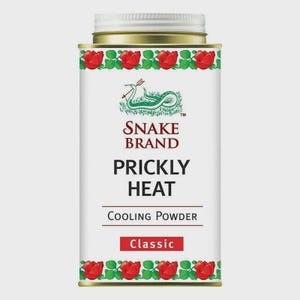 May include: A white rectangular tin of Snake Brand Prickly Heat Cooling Powder. The tin has a gold lid and a red rose border. The text "Snake Brand" and "Prickly Heat" are prominently displayed, along with the words "Cooling Powder" and "Classic".