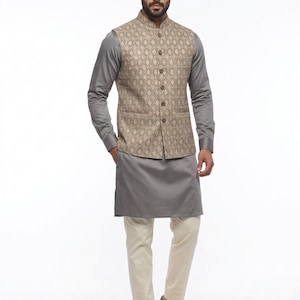 May include: A formal outfit featuring a gray kurta and off-white pants. A tan vest with a diamond pattern is worn over a gray long-sleeve shirt. Brown leather shoes complete the ensemble. The outfit is suitable for special occasions.