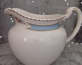 Jarra de leche Johnson Bros Made in England con borde azul y estampado de flores.