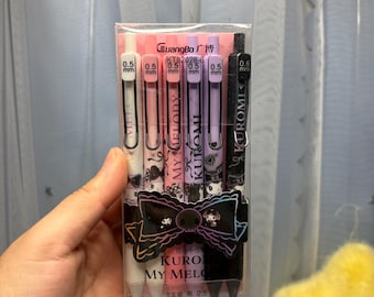 Può includere: Un set di sei penne gel da 0,5 mm in una custodia di plastica trasparente, con disegni dei personaggi Kuromi e My Melody in bianco, rosa e nero. Le penne hanno clip retrattili e riportano il marchio GuangBo e la scritta Kuromi My Melody.