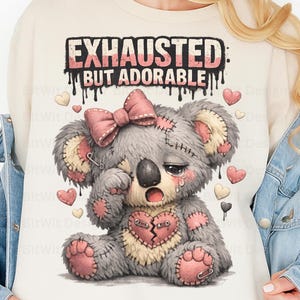 May include: An illustration of a grey koala bear with a pink bow and stitched patches, looking sad. The text reads "EXHAUSTED: BUT ADORABLE". Pink and white hearts are scattered around the koala.