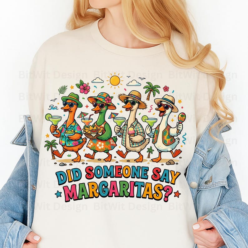 May include: A cream-colored sweatshirt featuring a graphic of four ducks wearing hats and sunglasses, holding margaritas and snacks. The text below reads, "DID SOMEONE SAY MARGARITAS?" The design includes palm trees, flowers, and a sun in the background.