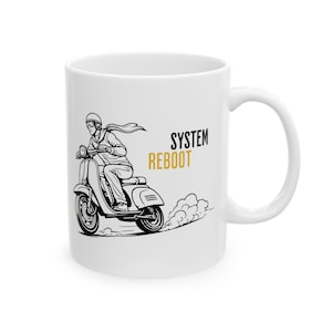 Könnte beinhalten: Weiße Keramiktasse mit einer Schwarz-Weiß-Illustration einer Person auf einem Vintage-Roller. Der Text "SYSTEM REBOOT" ist in Schwarz und Gold auf die Tasse gedruckt. Die Tasse hat einen gebogenen Griff.