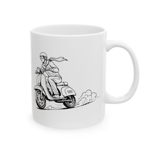 Könnte beinhalten: Weiße Keramiktasse mit einer Schwarz-Weiß-Illustration einer Person auf einem Vintage-Roller. Das Design umfasst einen Helm, einen Schal und eine Abgaswolke, die eine Retro-Ästhetik erzeugt. Die Tasse hat einen gebogenen Griff.