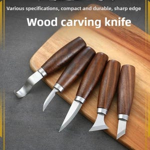 Puede incluir: Cinco cuchillos para tallar madera con mangos de madera marrón oscuro y hojas plateadas se muestran sobre una tabla de cortar de madera. El texto "Wood carving knife" es visible. Los cuchillos tienen varias formas de hoja.