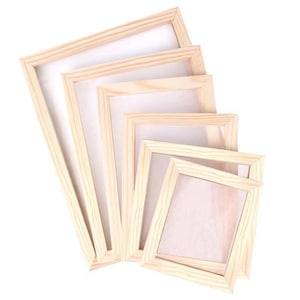 Op de afbeelding: Een set van vijf rechthoekige houten frames gerangschikt in een trapsgewijze stapel van groot naar klein. Elk frame heeft een lichtbruine natuurlijke houtnerfafwerking en een dun, plat profiel rondom een wit, halfdoorzichtig gaasscherm.