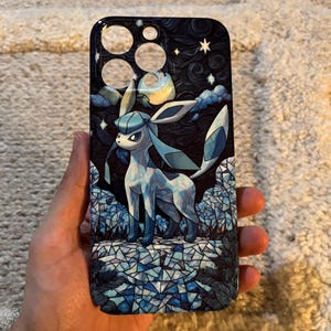 May include: A phone case with a cartoon character in shades of blue and white, set against a dark blue night sky with stars and a moon. The design has a stained-glass effect, with the character standing on a mosaic-like surface.