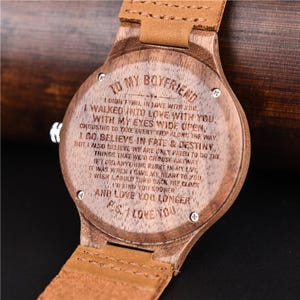 Puede incluir: Reloj de pulsera de madera con correa de cuero marr&oacute;n claro. La esfera del reloj est&aacute; grabada con un mensaje rom&aacute;ntico: "Para mi novio... Te amo". El reloj tiene un dise&ntilde;o cl&aacute;sico y un acabado de veta de madera natural.
