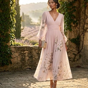 Puede incluir: Un vestido midi de color rosa pálido con escote en V, mangas largas transparentes tipo obispo y falda plisada. La tela presenta un delicado estampado floral en tonos suaves. El vestido incluye una cintura ajustada y un pequeño bolso dorado.