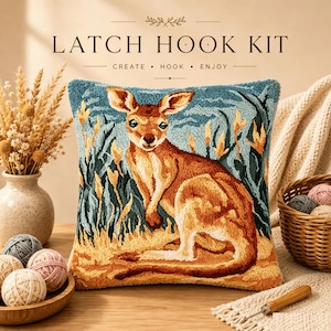 Peut inclure: Un coussin de kit de crochet à loquet carré représentant un kangourou brun dans un champ herbeux aux tons bleus et jaunes. Le texte LATCH HOOK KIT CREATE HOOK ENJOY est imprimé au-dessus. Le motif utilise du fil texturé pour l'animal.
