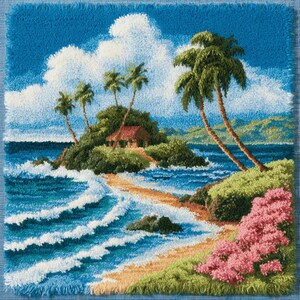 May include: A square latch hook rug featuring a tropical island scene with a small hut, palm trees, and a sandy beach. The ocean has white-capped blue waves, and the foreground includes green foliage with clusters of pink flowers under a blue sky.