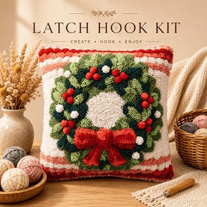 Könnte beinhalten: Ein Knüpfset mit einem quadratischen Kissen mit strukturiertem Weihnachtskranz-Motiv. Der Kranz besteht aus grünem Laub, roten Beeren und einer großen roten Schleife auf einem cremefarbenen und rot gestreiften Hintergrund. Text LATCH HOOK KIT CREATE HOOK ENJOY.