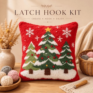 May include: A square latch hook kit cushion featuring a vibrant red background with three green Christmas trees decorated with red and yellow ornaments, white snow, and white snowflakes. The text LATCH HOOK KIT CREATE HOOK ENJOY is visible.