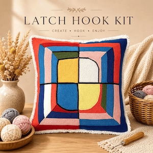 Peut inclure: Un coussin de kit de crochet à loquet carré avec un motif géométrique en rouge, bleu, jaune, rose, blanc et vert olive. Le texte LATCH HOOK KIT CREATE HOOK ENJOY est imprimé au-dessus. Le coussin présente une bordure à franges blanches.