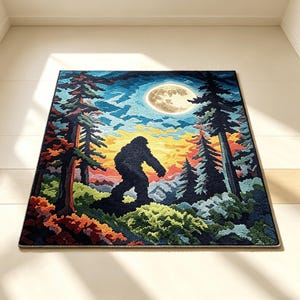 May include: A rectangular area rug featuring a tufted graphic of a dark silhouette of a creature resembling Bigfoot standing in a forest at night. The scene includes tall pine trees, a large full moon, and a sunset sky with orange and yellow hues.