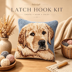 Op de afbeelding: Een latch hook kit met een vierkant kussen met een getextureerd ontwerp van een golden retriever op een blauwe achtergrond. De tekst LATCH HOOK KIT CREATE HOOK ENJOY staat erboven. De kit bevat garenbollen en een latch hook gereedschap.
