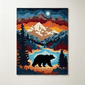 May include: A rectangular tufted wall hanging featuring a landscape scene with a black bear in the foreground, a blue river, evergreen trees, and snow-capped mountains under a dark blue sky with a white moon, rendered in textured yarn.