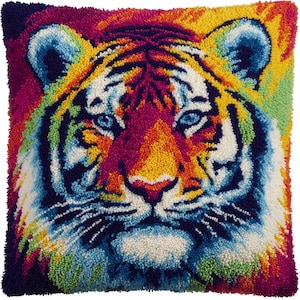 May include: A square cushion with a colourful tiger face design. The tiger's face is depicted in shades of blue, yellow, orange, and purple. The cushion has a textured, handmade appearance, with a variety of colours.