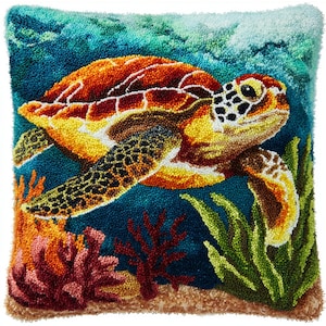 Könnte beinhalten: Ein quadratisches, handgenähtes Kissen mit einer Meeresschildkröte unter Wasser. Die Schildkröte hat einen braunen und gelben Panzer mit detailliertem Gesicht und Flossen. Der Hintergrund ist tiefblau, mit Korallen- und Algenakzenten. Das Kissen misst etwa 40 cm im Quadrat.