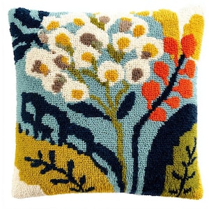 May include: A square throw pillow featuring a textured punch needle design. The pattern displays white and yellow floral clusters against a light blue background, accented by dark navy, bright orange, and olive green botanical shapes.