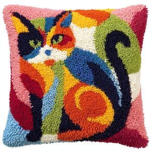 May include: Square cushion with a colourful cat design. The cat is rendered in vibrant shades of orange, blue, green, and yellow, with a pink border. The cushion is made from a textured, tufted material, perfect for adding a pop of colour.