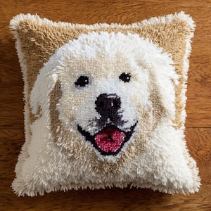 Könnte beinhalten: Quadratisches Zierkissen mit einem lächelnden Hundegesicht. Das Gesicht des Hundes ist überwiegend weiß mit beigen Akzenten, schwarzen Augen und einer rosa Zunge. Das Kissen hat ein strukturiertes, getuftetes Aussehen und einen beigen Rand. Ca. 30 cm.