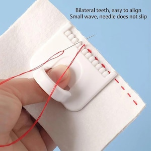May include: A white plastic sewing guide with a series of teeth, used for aligning stitches. Red thread is threaded through the needle and fabric. Text on the image reads: Bilateral teeth, easy to align. Small wave, needle does not slip.