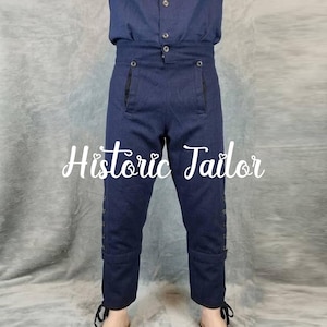 Könnte beinhalten: Dunkelblaue Hose mit hoher Taille, Knopfverschluss vorne, zwei Vordertaschen und einer Knopfleiste an der Außenseite jedes Beins. Der Text Historic Tailor ist mittig über das Bild gelegt.