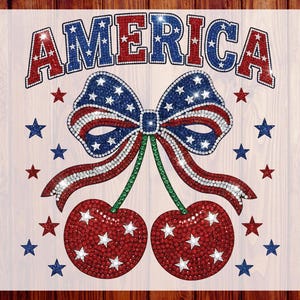 May include: A design with the word "AMERICA" in red and blue rhinestones, a bow, and two cherries decorated with stars and stripes. The design is surrounded by red and blue stars. Ideal for celebrating American Independence Day or other patriotic events.