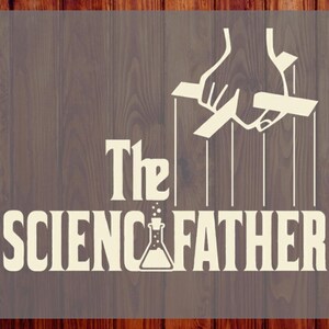 May include: A cream-colored graphic transfer featuring the text The SCIENCFATHER with a laboratory flask replacing the letter I. Above the text is a white illustration of a hand operating marionette strings. The text CUSTOM DTF READY TO PRESS is visible on the sides.