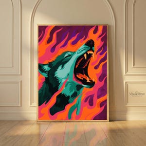 Könnte beinhalten: Ein gerahmter Kunstdruck mit einem stilisierten Wolf mit offenem Maul, vor einem Hintergrund aus leuchtend orangefarbenen, rosa und lila Flammen. Das Fell des Wolfes ist türkis und dunkelgrün. Das Kunstwerk wird auf einem Holzboden ausgestellt.