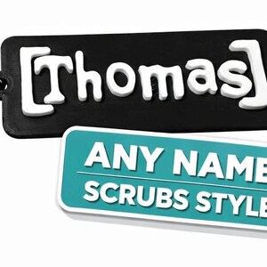 Könnte beinhalten: Ein schwarzer, rechteckiger Schlüsselanhänger mit dem Namen "Thomas" in weißen Blockbuchstaben. Darunter befindet sich ein türkisfarbenes rechteckiges Etikett mit der Aufschrift "ANY NAME SCRUBS STYLE" in weißen Buchstaben. Der Schlüsselanhänger hat einen silbernen Schlüsselring.