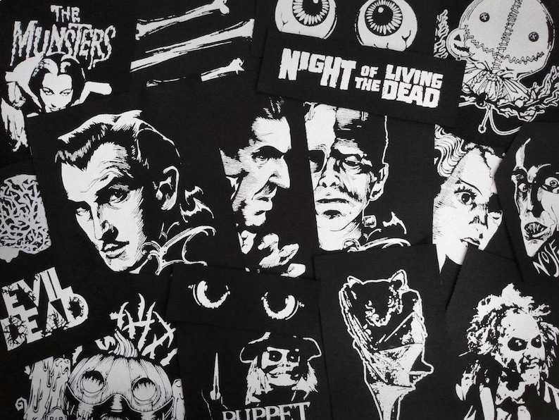 May include: A collection of black and white patches featuring classic horror movie characters and titles. Patches include images of Dracula, Frankenstein, and the Bride of Frankenstein, along with text like "Night of the Living Dead" and "The Munsters."
