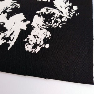May include: Black fabric patch with a white design of abstract shapes.