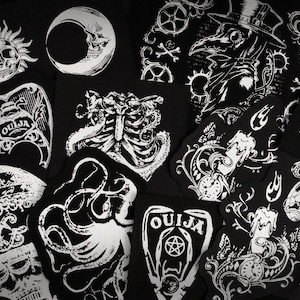 May include: A collection of black and white patches featuring gothic and occult designs. Images include a skull sun, a crescent moon skull, a Ouija board, an octopus, a plague doctor, and a cat skull.