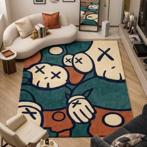 Pu&ograve; includere: Un tappeto rettangolare con un motivo grafico raffigurante mani e volti in stile cartone animato con occhi a forma di X, nei toni del verde ottanio, crema e arancione bruciato. Il design presenta contorni neri e forme circolari.