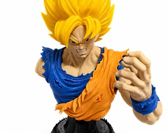 May include: A bust figurine of a character with spiky yellow hair, wearing a torn blue and orange shirt. The figure has a clenched fist and is mounted on a black circular base featuring a small orange sphere with a red star and dragon detail.